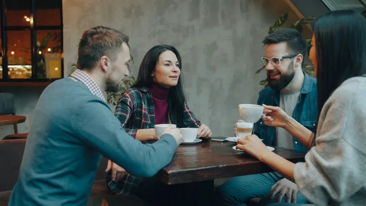 Pessoas conversando à mesa com café